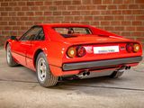 a red sports car parked in front of a brick wall