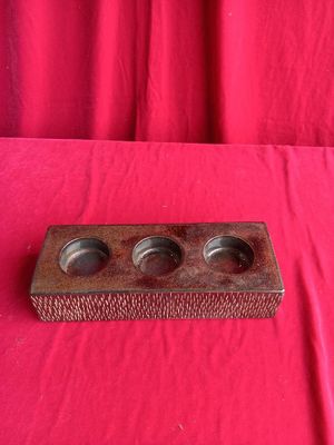 a wooden tray with three cups on it on a red cloth