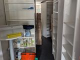 une petite pièce avec des étagères et une table à l'intérieur