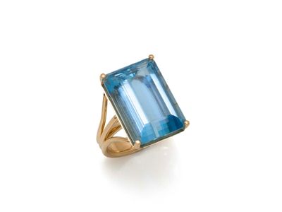 une bague en topaze bleue avec un anneau en or et une émeraude