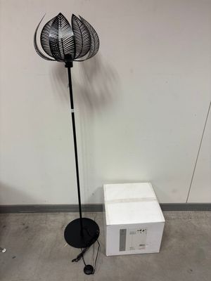une lampe posée par terre à côté d'un micro-ondes