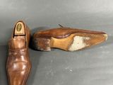 pair of men ' s brown leather shoes sitting on a gray surface