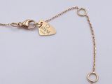 a close up of a gold chain with a heart charm on it