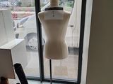 a mannequin on display in a window next to a pair of shoes