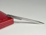 a red book with a silver pen on top of it