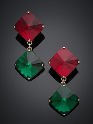 une paire de boucles d'oreilles émeraude et rouges sur fond noir