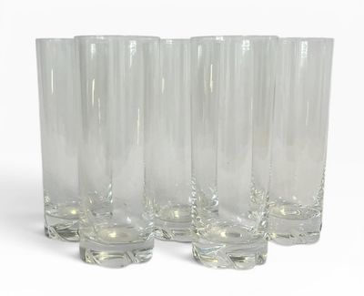 quatre verres transparents sont alignés sur une surface blanche