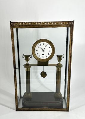 Pendule portique en bronze vers 1800 à décor d’urnes sur le …