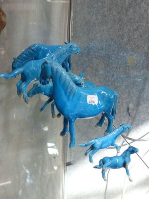 a lot of blue horses that are on display in a glass case