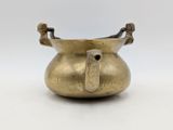 an old brass pot with a handle on a white background
