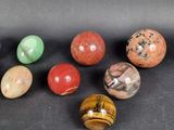 six different types of marbles arranged in a row on a black surface