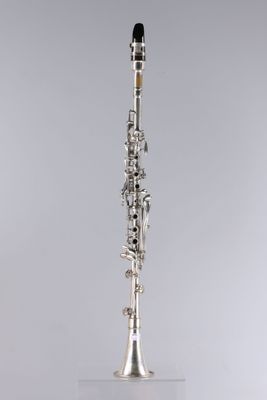 a silver and black clarinet on a white surface