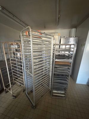 many trays of food that are on a rack in the kitchen