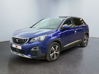 La voiture bleue est garée dans une grande pièce au sol noir.