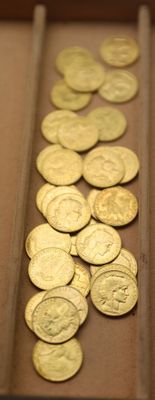beaucoup de pièces d'or dans une boîte posée sur la table