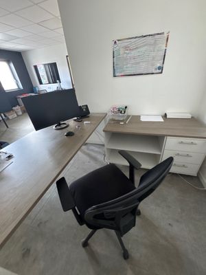a desk with a computer and a chair in the room
