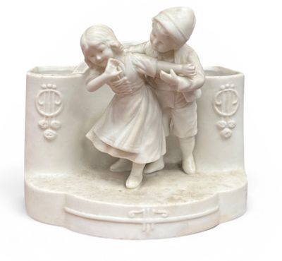 une figurine blanche représentant deux enfants en train de jouer ensemble