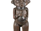 une vieille statue en bois d'un homme avec un chapeau sur la tête
