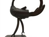sculpture représentant un oiseau posé sur un socle, sur fond blanc