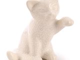 une petite figurine de chat blanc assis sur ses pattes arrière