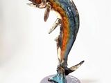 une statue représentant un poisson posée sur un socle