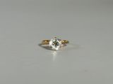 gros plan d'une bague en or avec un diamant blanc