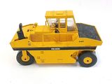 un petit camion jaune posé sur une surface blanche