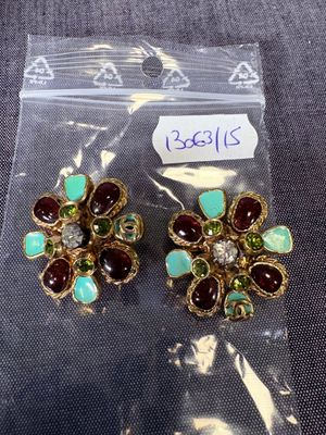 une paire de boucles d'oreilles ornées de pierres vertes et rouges