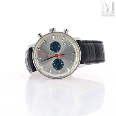 a silver watch with a blue face on a white surface