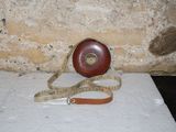 un mètre ruban enroulé autour d'un objet rouge posé sur une surface blanche