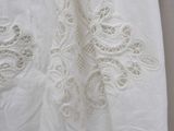 lace appliqued on a white shirt hanging on a hanger
