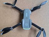 a small gray drone with four propellers on the ground