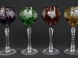 several different colored wine glasses are lined up in a row