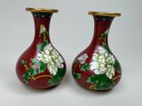 deux vases avec des fleurs peintes dessus, posés sur une table