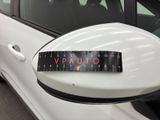 a white car with a sticker on it ' s side mirror