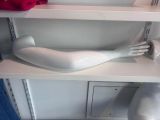 a white mannequin sitting on a shelf in a refrigerator