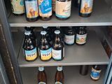 many bottles of beer sitting on the shelves in the refrigerator
