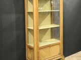 an old wooden cabinet with a glass door in a room