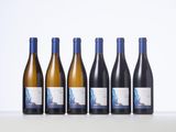 six bottles of wine lined up in a row on a table
