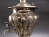 a silver vase with a handle on a black background