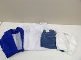 a pile of clothes on a table next to a pair of jeans