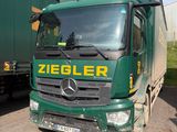 un camion vert garé à côté d'une remorque verte