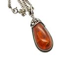 a close up of a necklace with a stone on a chain