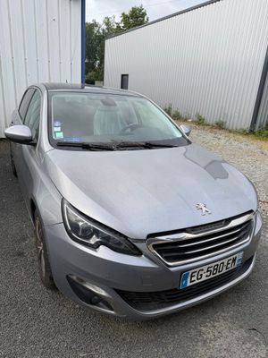 La voiture grise est garée devant un immeuble blanc.