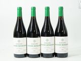 quatre bouteilles de vin sont alignées sur une surface blanche
