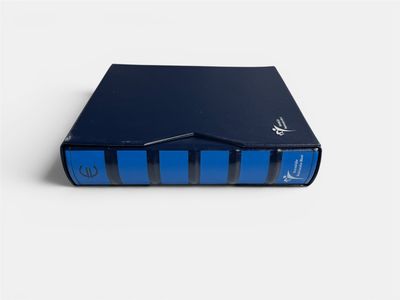 the blue book is sitting on a white surface next to a white wall