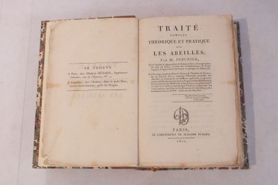 un livre ouvert posé sur une table, sur une surface blanche
