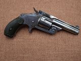 an old revolver on a brown surface with a black handle