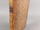 an old book sitting on top of a white surface