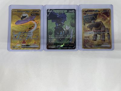 three different pokemon cards are sitting on a white surface
